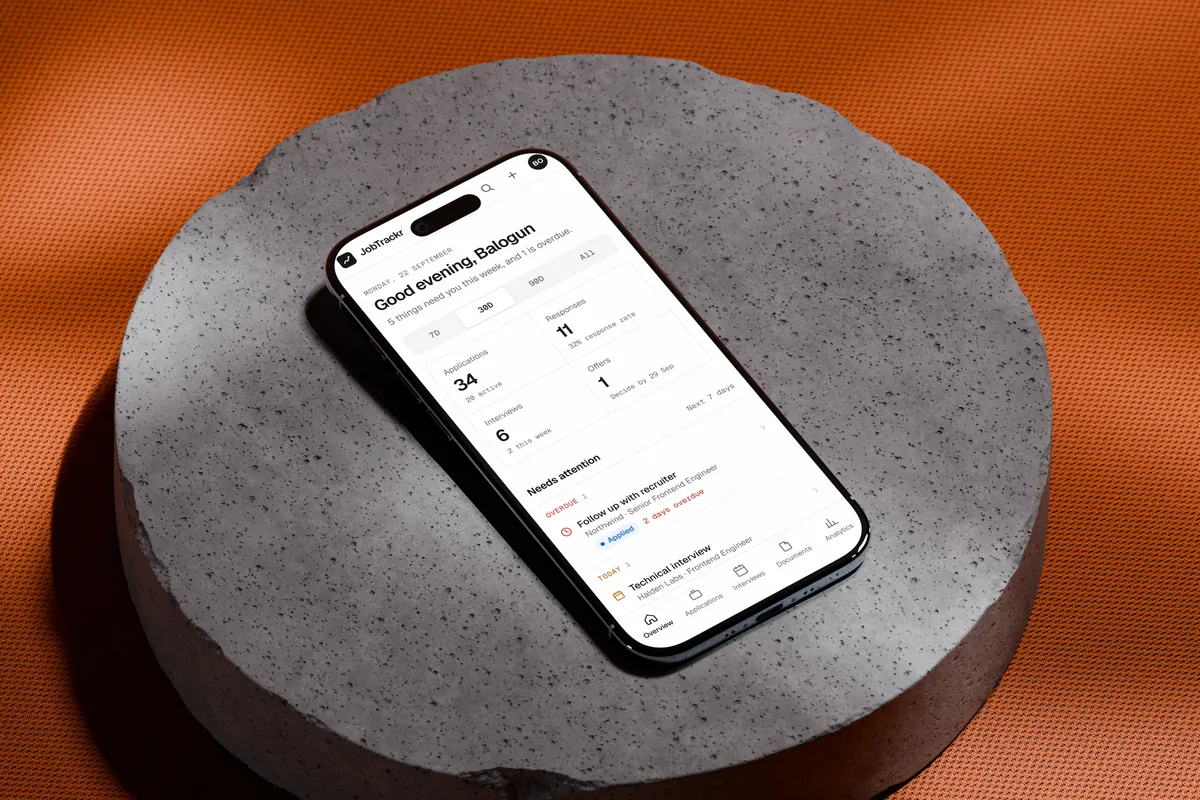 JobTrackr's Overview on a phone, resting on a concrete block
