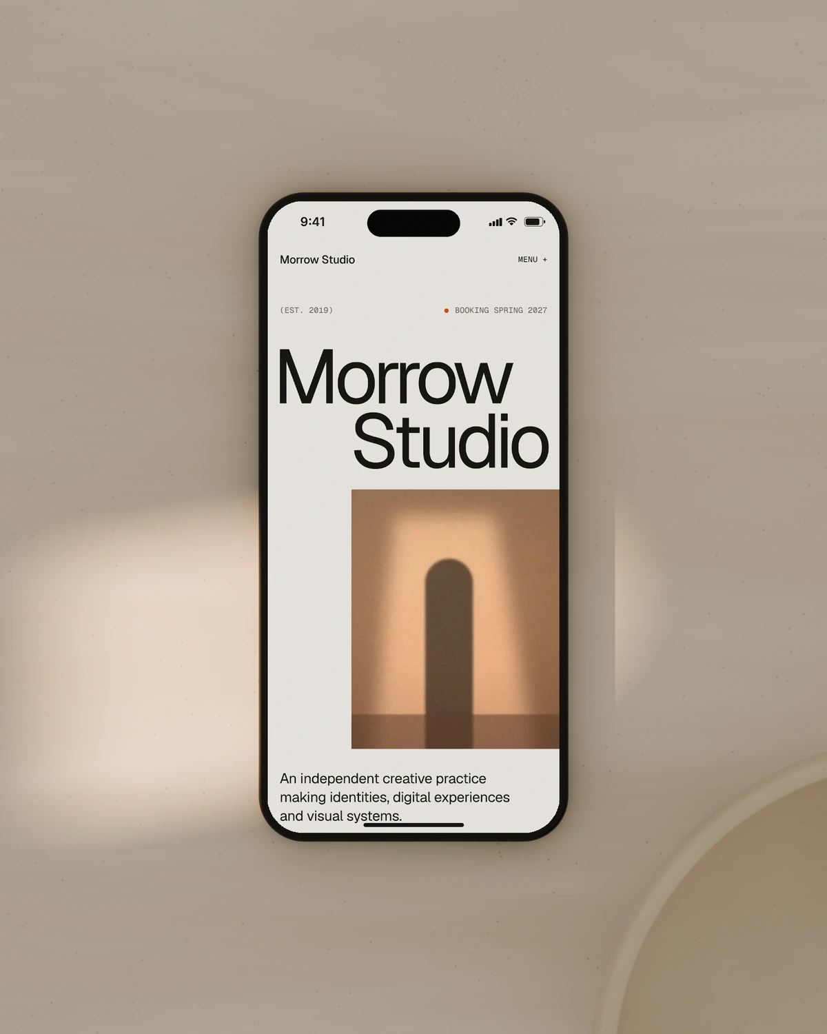 Morrow Studio's home page on screen, on a stone table in afternoon light