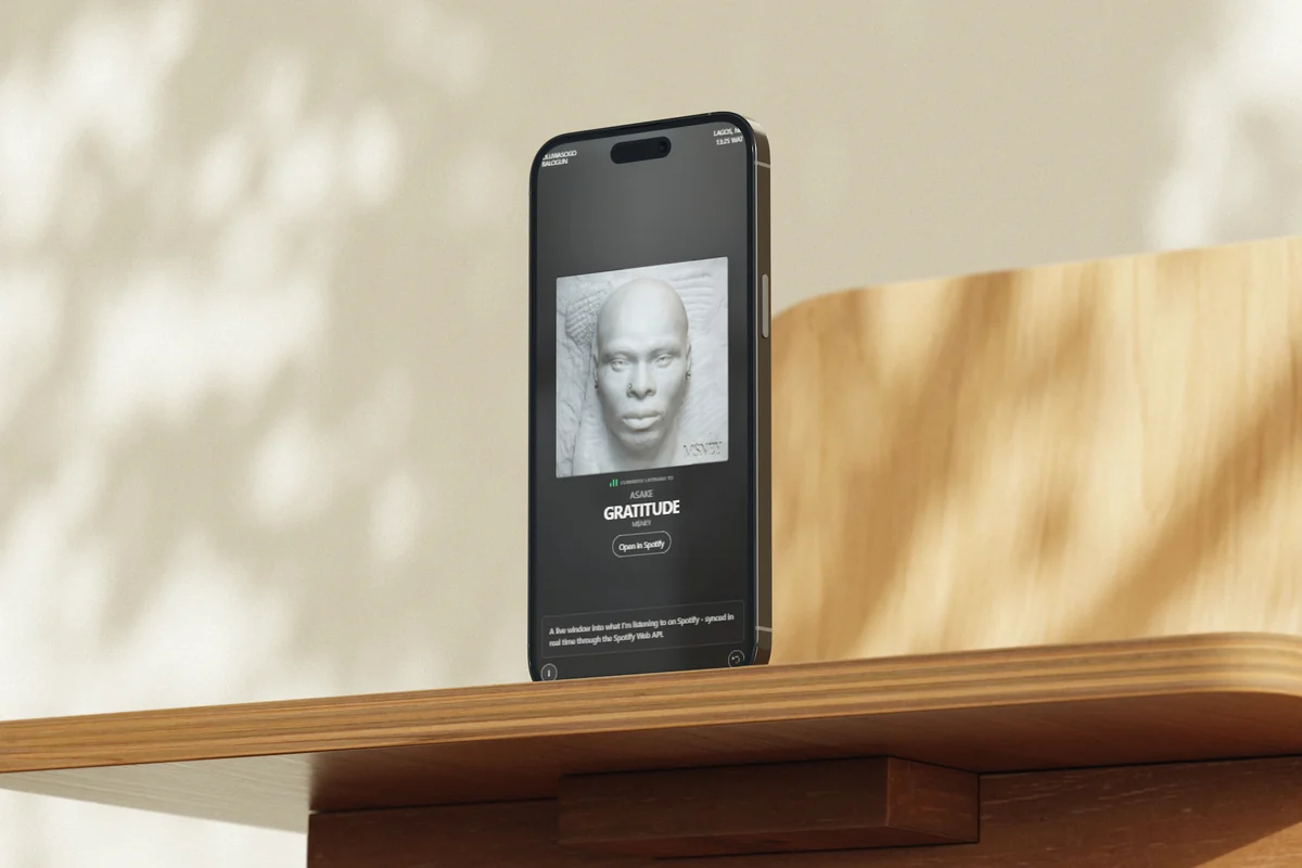 Now Playing on a phone standing on a wooden shelf, with the note about the page open